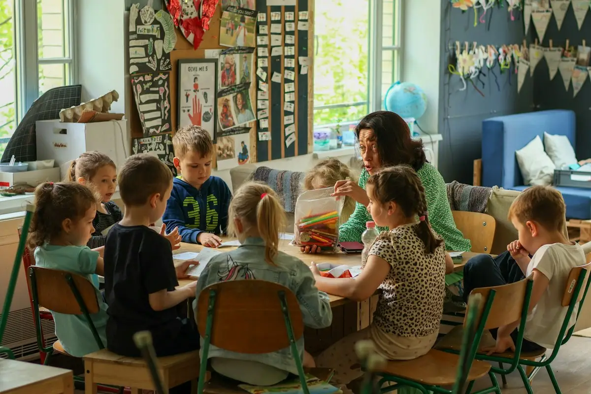 Erzieherin mit einer Gruppe Kinder am Basteltisch